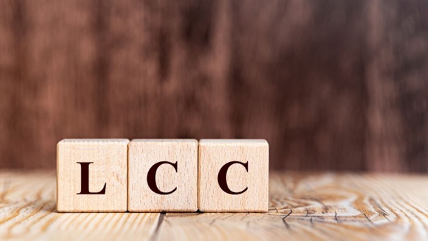 Scrabble blocks on a wood table that spell: LCC