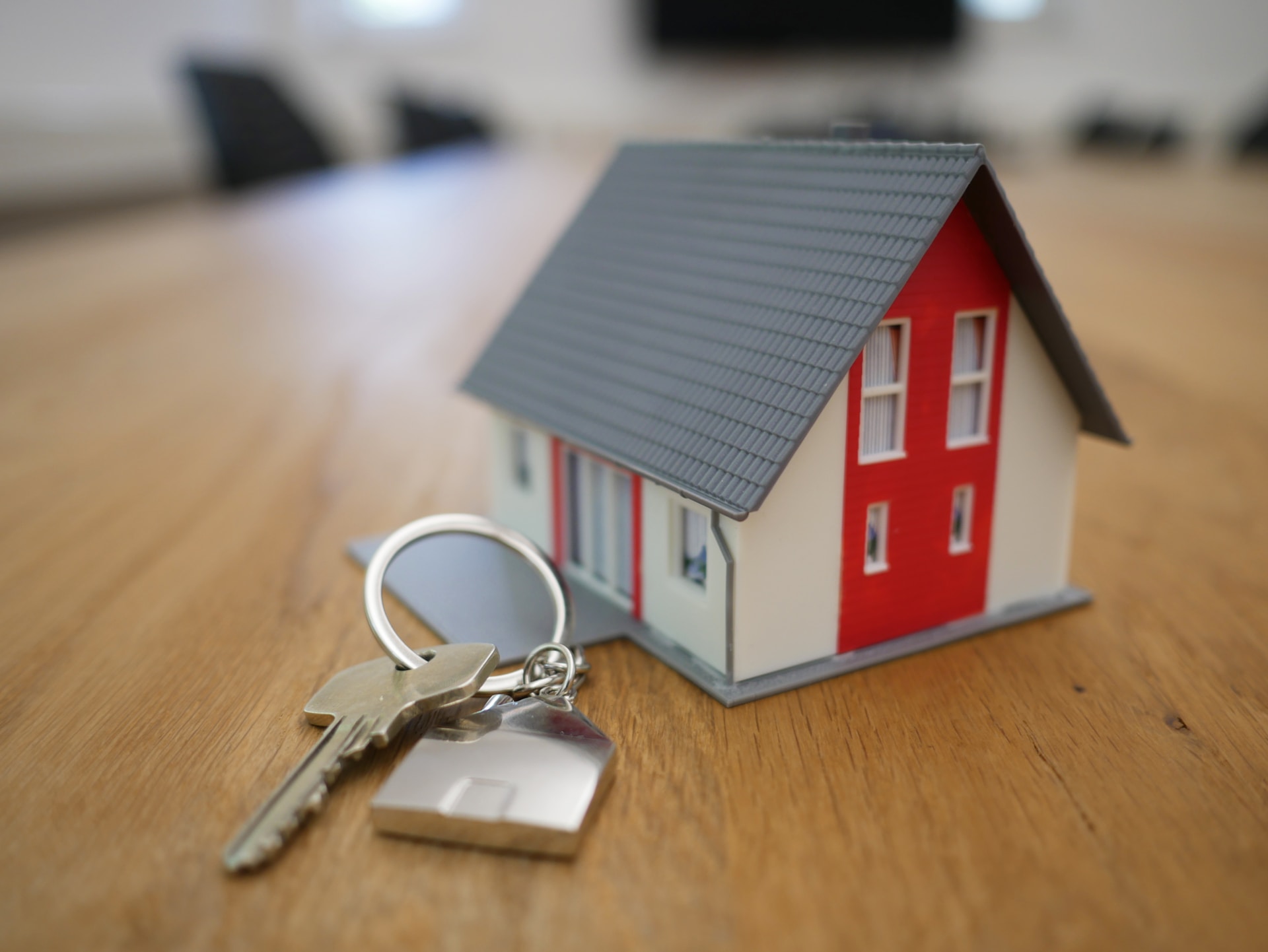 toy house and set of keys on a table - should you put your child on the deed to your home?